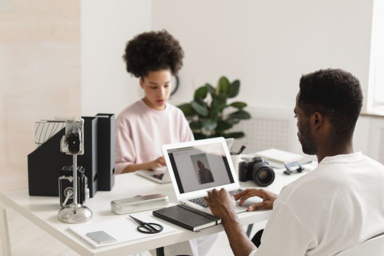 Tastemade lança Creator Lab com 11 criadores para aproximar marcas e influenciadores Dois profissionais criativos colaboram em um escritório moderno, diante de laptops e equipamentos de câmera.