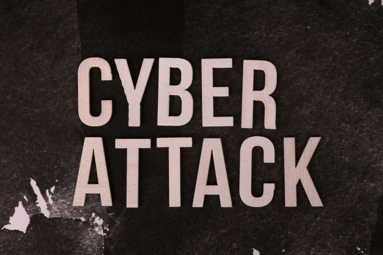 Roubo de dados coloca extorsão digital no centro de investigação da PF em Joinville Texto “Cyber Attack” sobre fundo escuro e texturizado, representando uma ameaça cibernética.