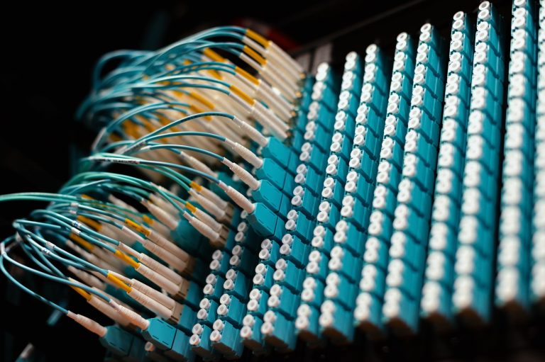 Cabos azuis finos conectados a pequenos terminais elétricos, em close.